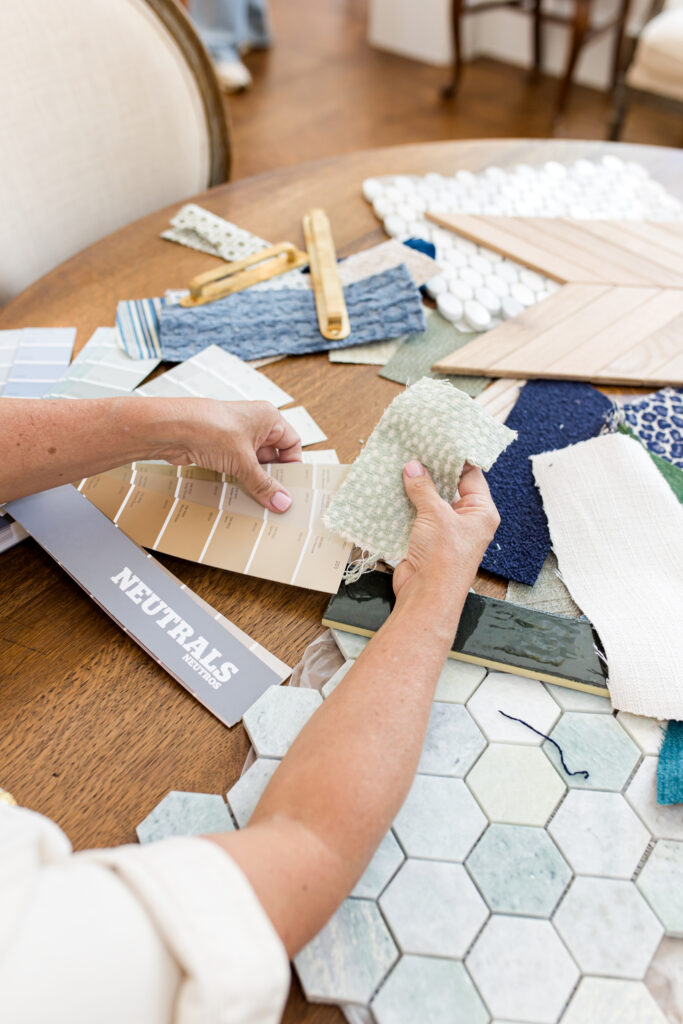 Designer reviewing paint, tile, and fabric swatches for a market-smart kitchen/bath remodel in Dallas–Fort Worth.