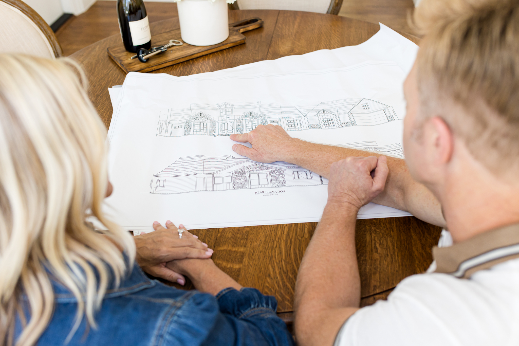 Homeowner and contractor review architectural elevations for a Dallas renovation—clear scope, timeline, and ROI-smart decisions.